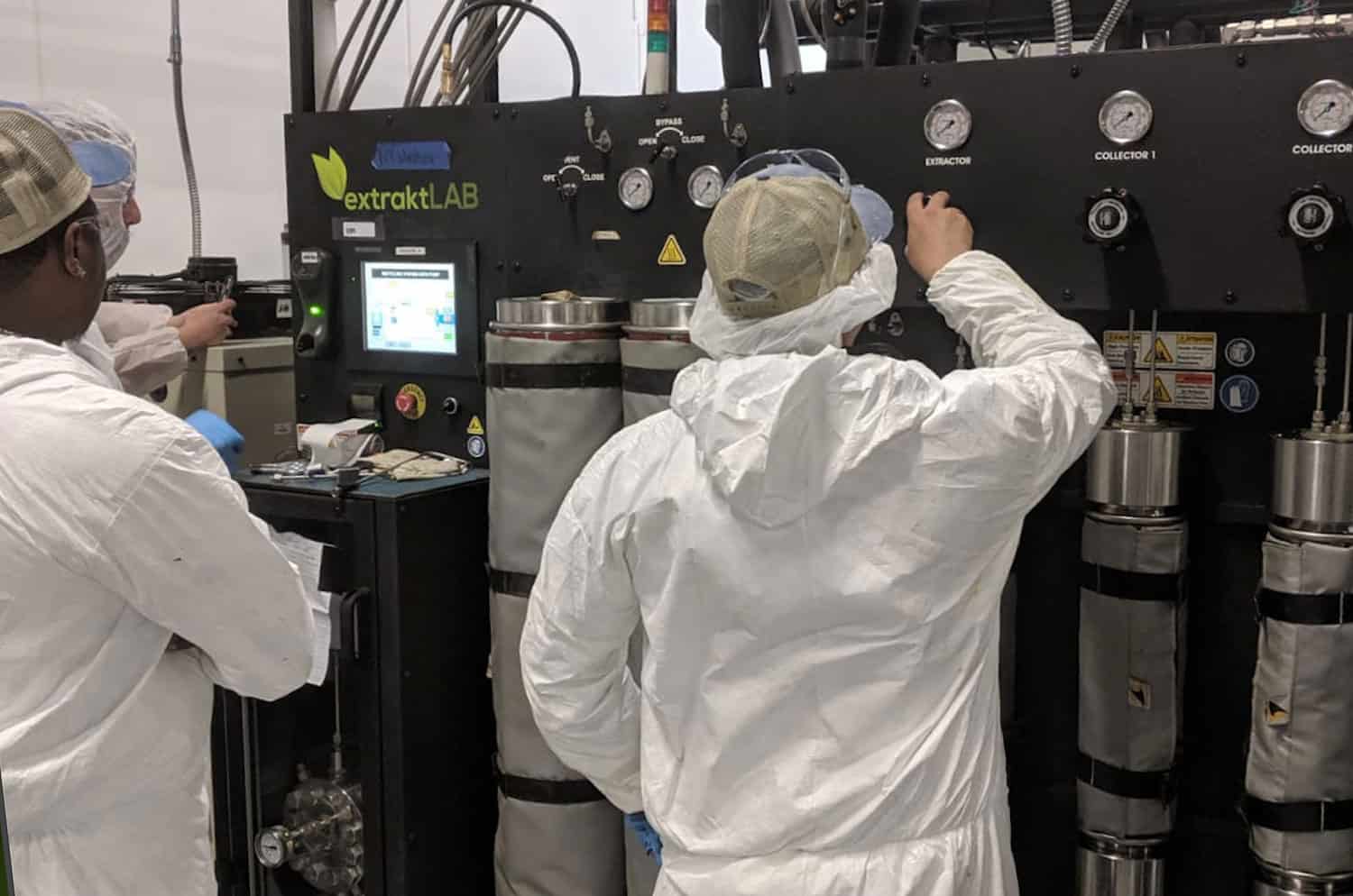 scientist in lab coat using extraktLAB machine