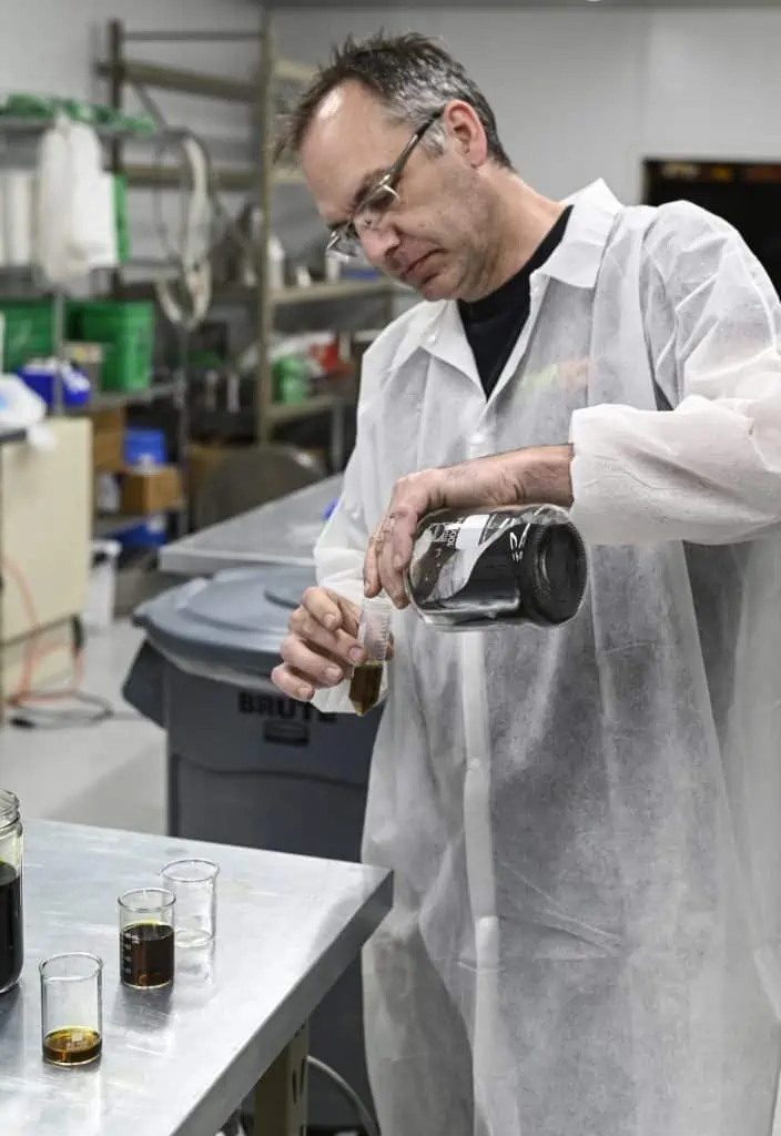man measuring chemicals in lab gear