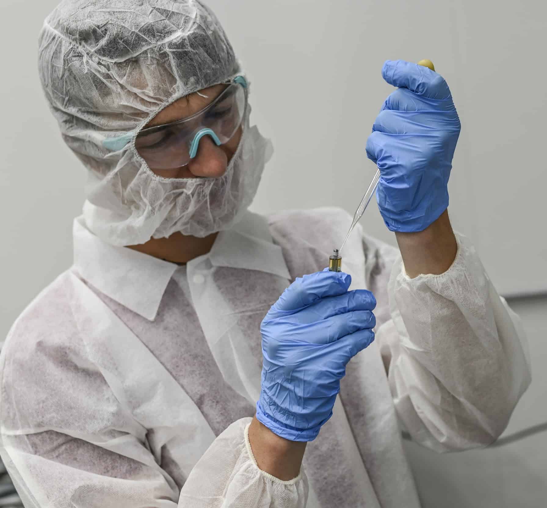 man in lab coat checking solution