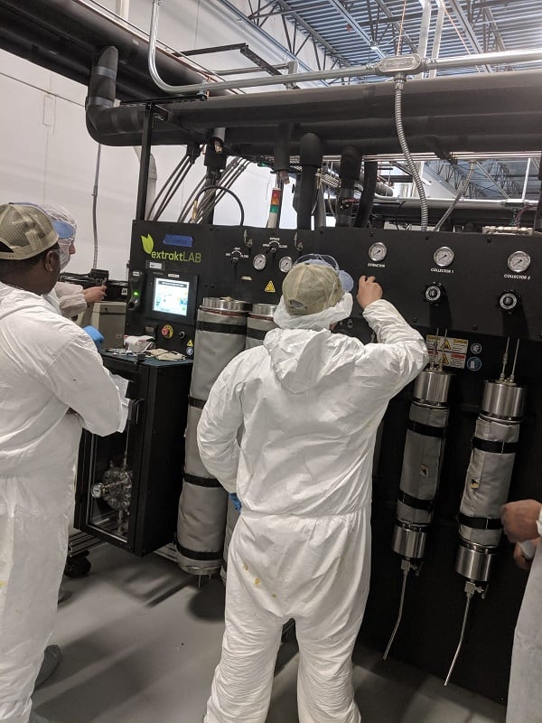 man doing some adjustment on extractor machine